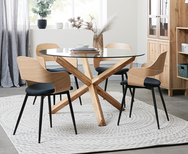 Round glass dining table with chunky wooden legs with wooden and metal ergonomic design dining chairs