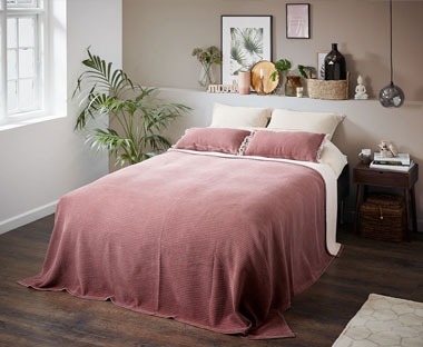 dark pink bed throw covering double bed in boho style room