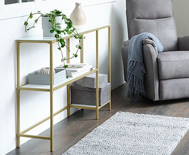 tempered glass console table with gold metal detailing 