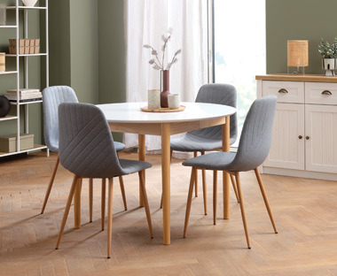 Light grey dining chairs and a round shape dining table 
