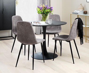 Round black dining table with grey corduroy dining chairs