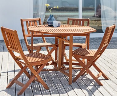 folding wooden garden chairs placed around a matching wooden garden table