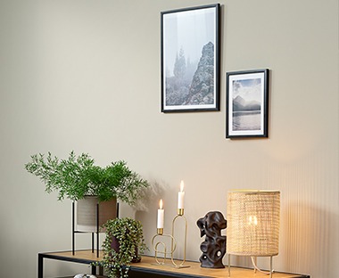 black wooden picture frame hung on a wall above a tv stand