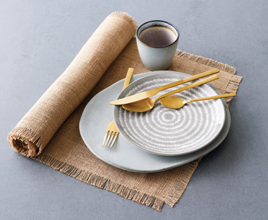 Table runner with plates and golden cutlery on top
