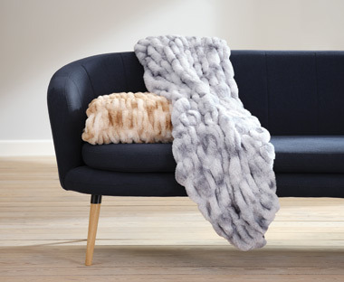 Pink-Grey Fake fur throw on top of blue sofa