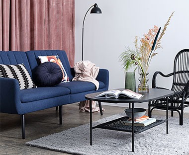 Stylish blue sofa bed with black wooden legs