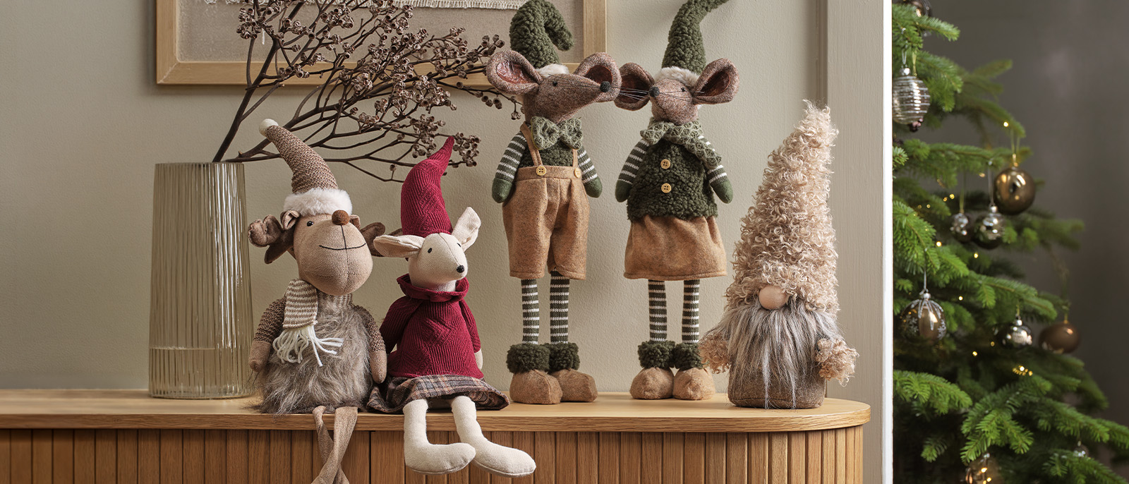 Scandinavian Christmas elves and Christmas mice are beloved companions throughout the Christmas holidays Christmas gnomes, Christmas elves and Christmas mice on a sideboard with Christmas tree in background