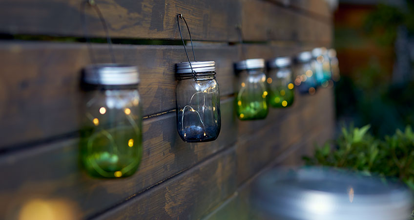 Green and blue lanterns hanging on garden fench