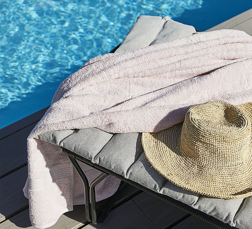 Sun lounger with cushion by a swimming pool 