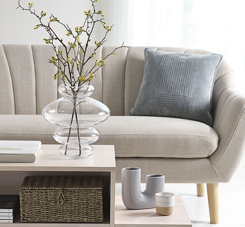 Bright living room with playful vases on coffee table and beige sofa