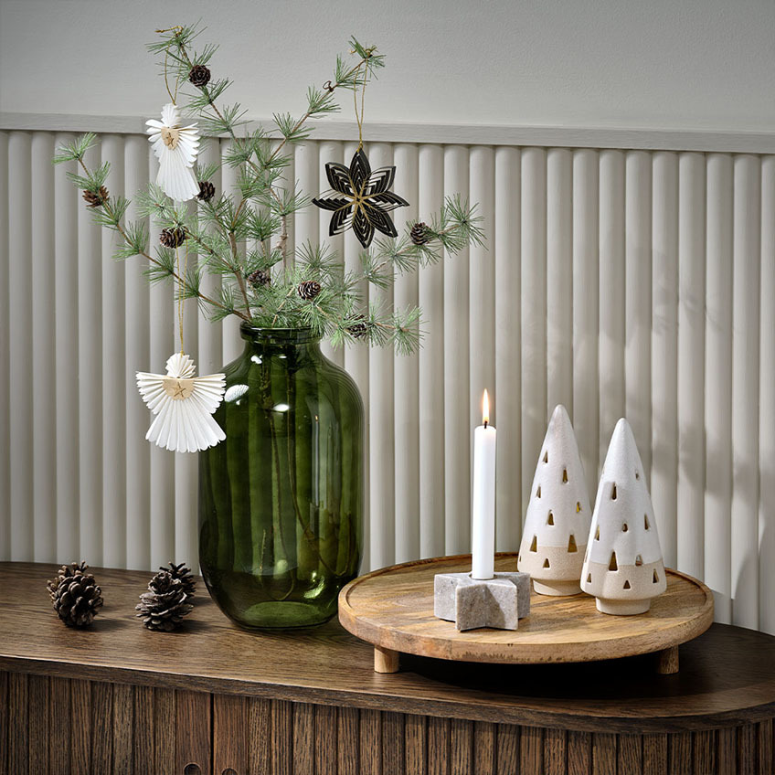 Artificial fir twig in green vase with Scandinavian Christmas décor 