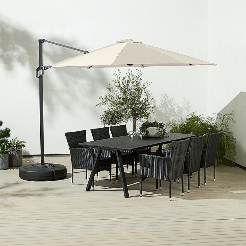 Large, square off-white hanging parasol above outdoor dining table with garden chairs