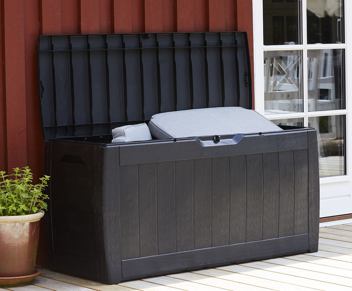 Black cushion storage box with an open lid on a patio