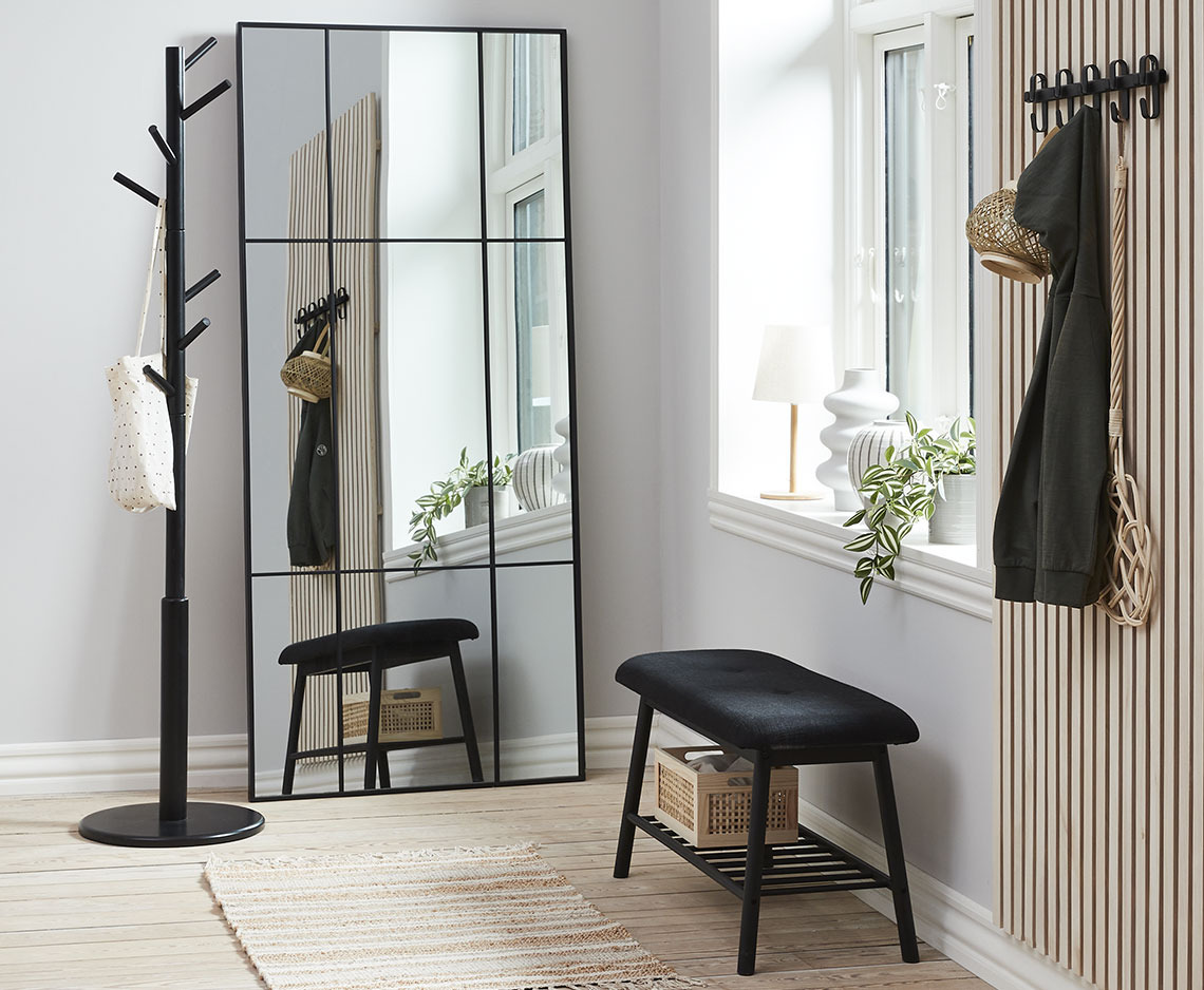 Hallway with large mirror, hallway bench in dark colours and coat stand