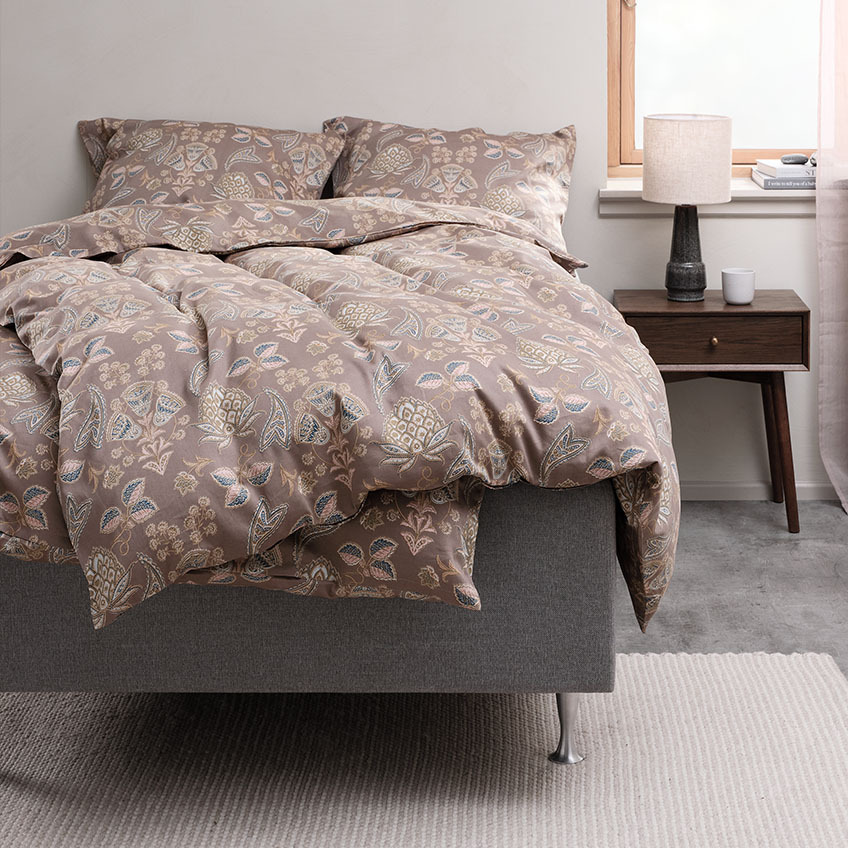 Duvet cover set and cotton bedding with paisley design on bed in bedroom 