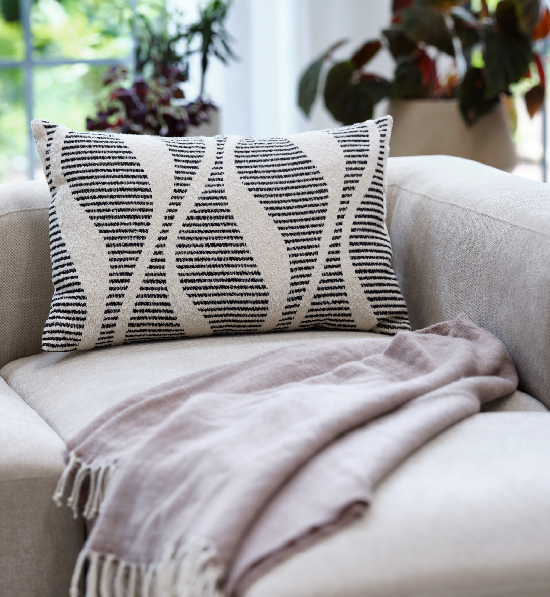 black abstract cushion and pink throw