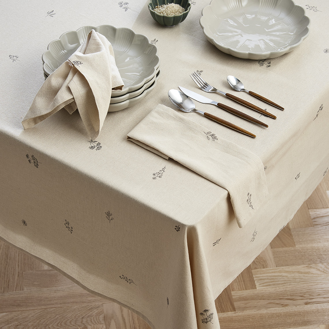 Dining table with tablecloth, plates, and tableware 