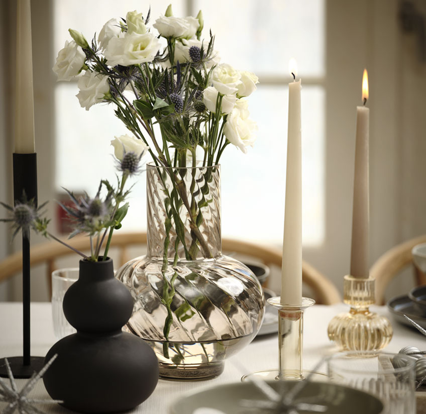 Black vase and glass vase with flowers on a New Year’s table