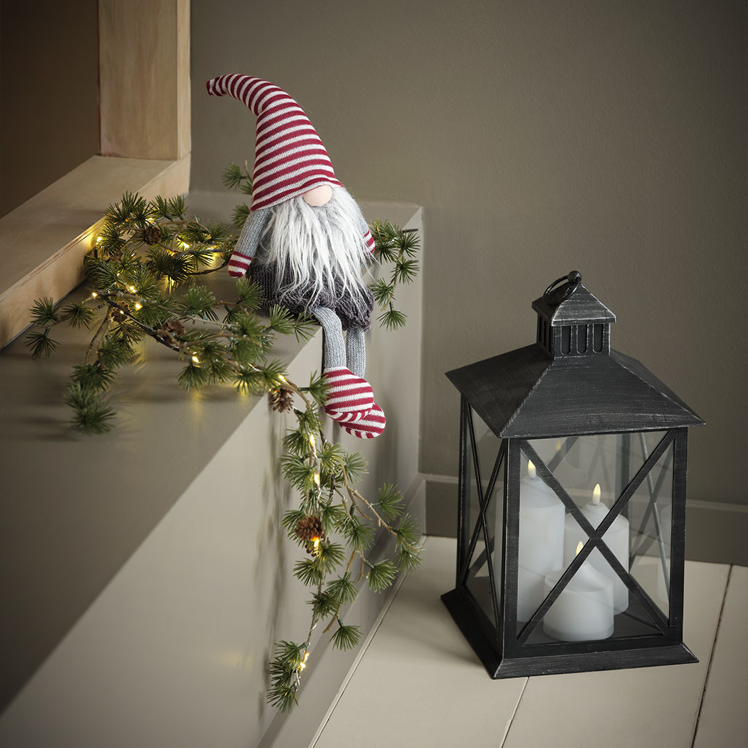 SVADILFARI Christmas elf and PULKA lantern Christmas elf with hat, gloves, and socks with red stripes next to black lantern