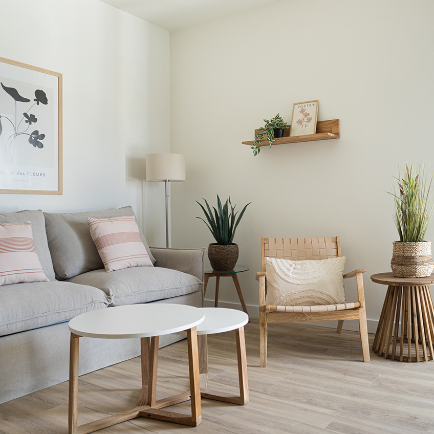 Living room area with sofa, armchair, coffee tables and decor