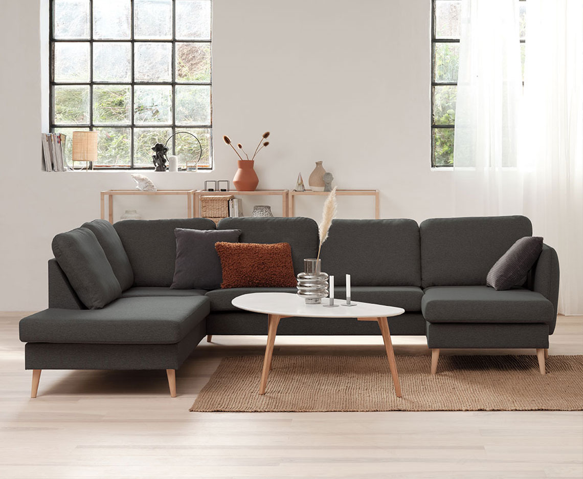 Dark grey corner sofa in a bright room with big windows