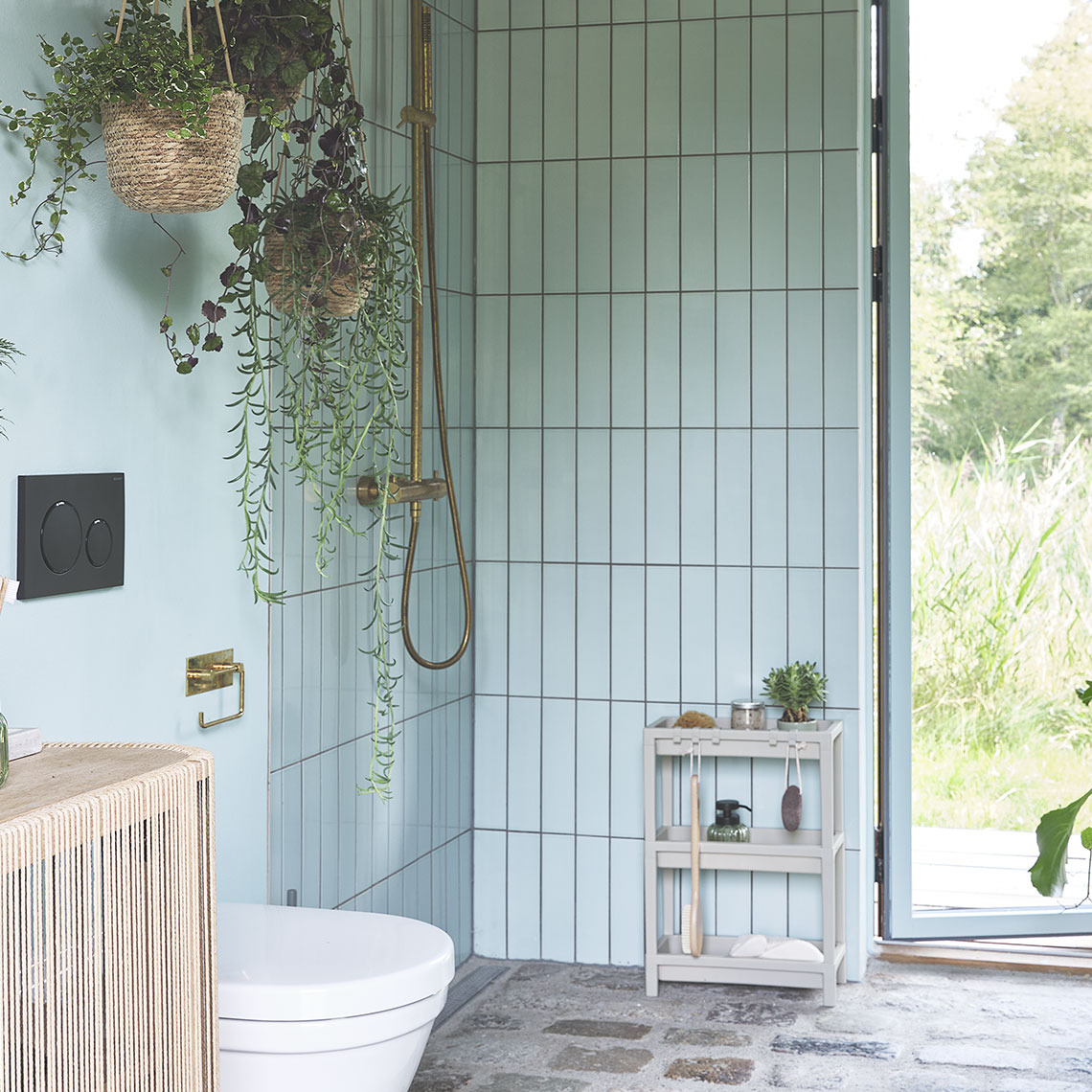 Bathroom space with a shower area, a shower storage, and some hanging plants