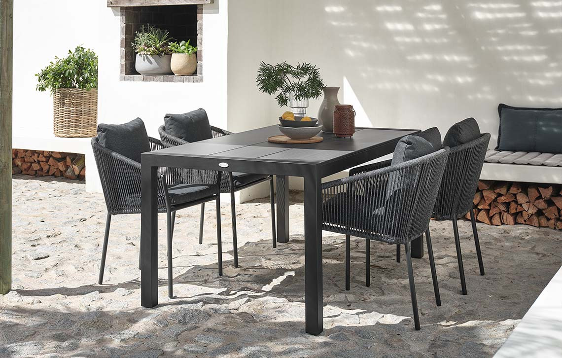 Garden table with composite wood table top and garden chairs with quick-dry cushions