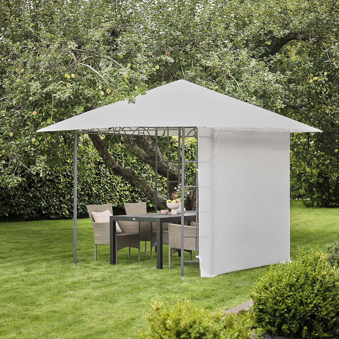 Beige gazebo with a beige side panel in a garden