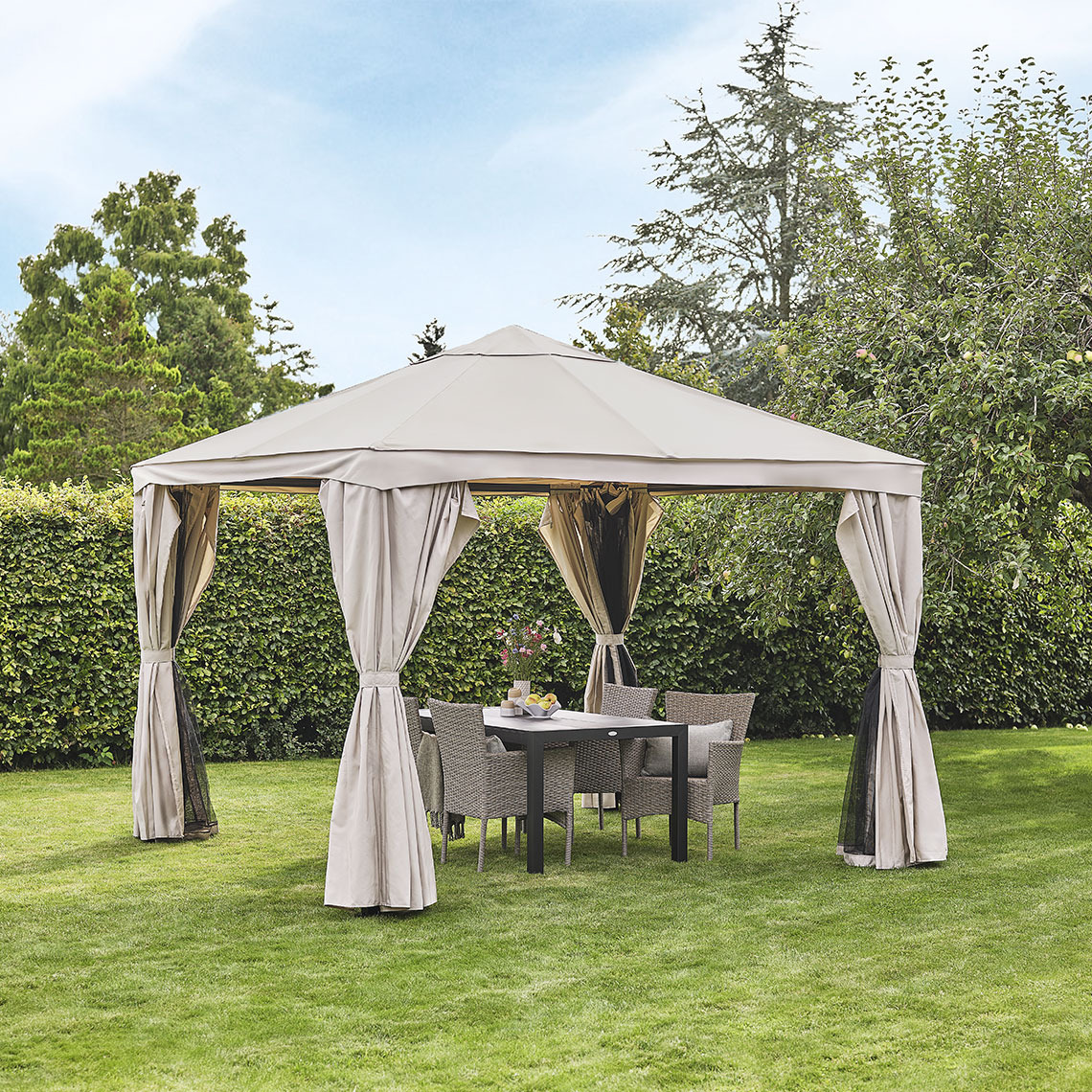 Beige gazebo in a garden with lounge furniture