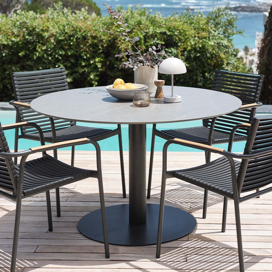 Garden table with fibre cement table top and garden chairs in garden 