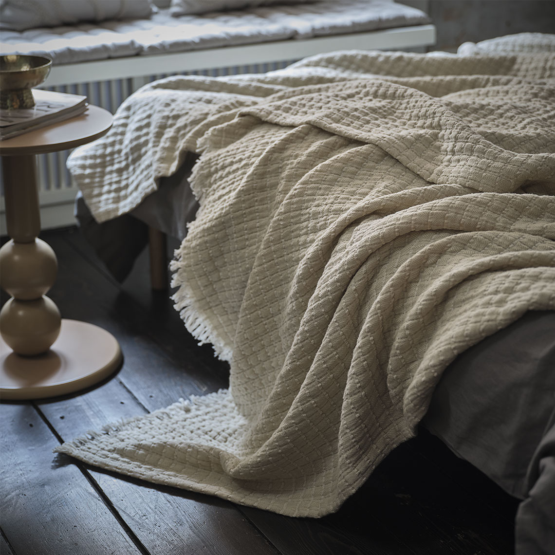 Beige throw on a bed in a sleeping room