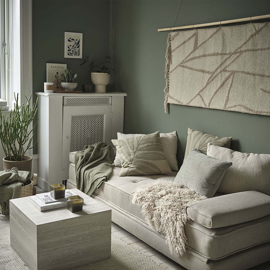 Living room with rugs, throws, and cushions in beige and green tones