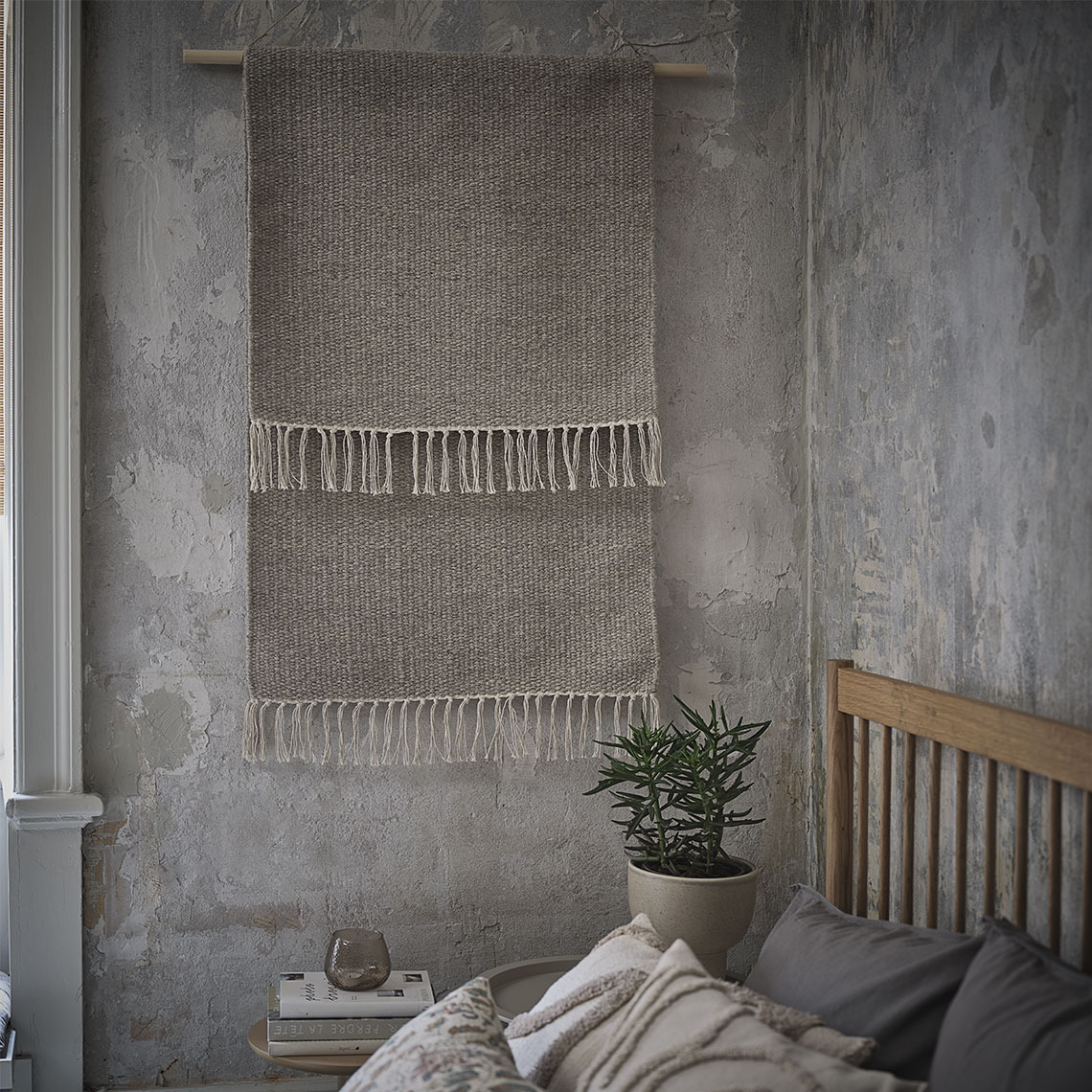 Grey rugs hanging on a wall