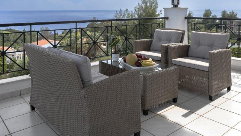 An outdoor patio space with JYSK lounge furniture, overlooking the beautiful ocean