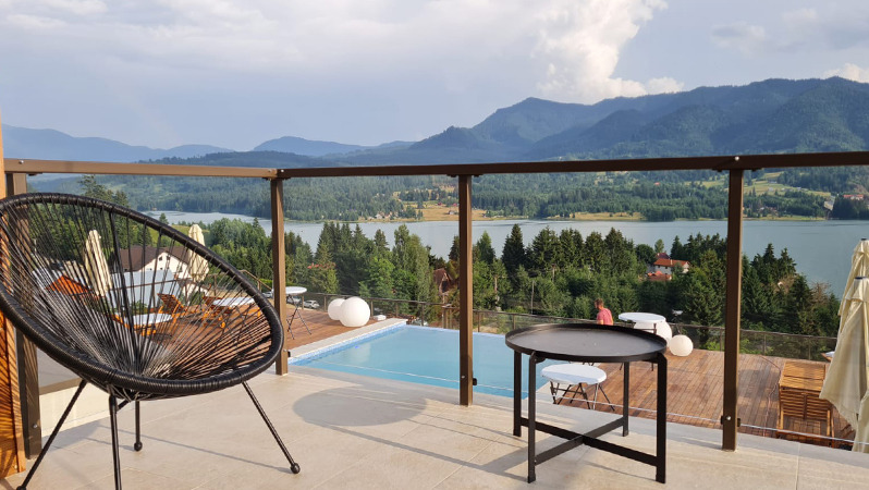 An outdoor area with a comfortable, JYSK lounge chair, overlooking the mountains and the lake