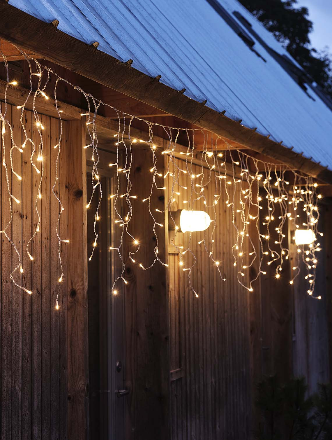 SNOTRA string lights with built-in timer String of lights shining in the darkness, hung on a home façade wall