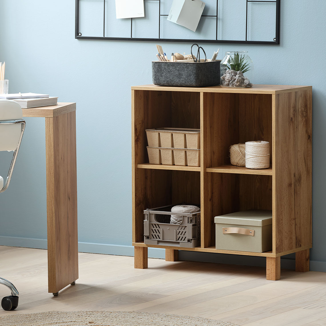 Modular wall storage unit component with four compartments, standing on floor with matching legs