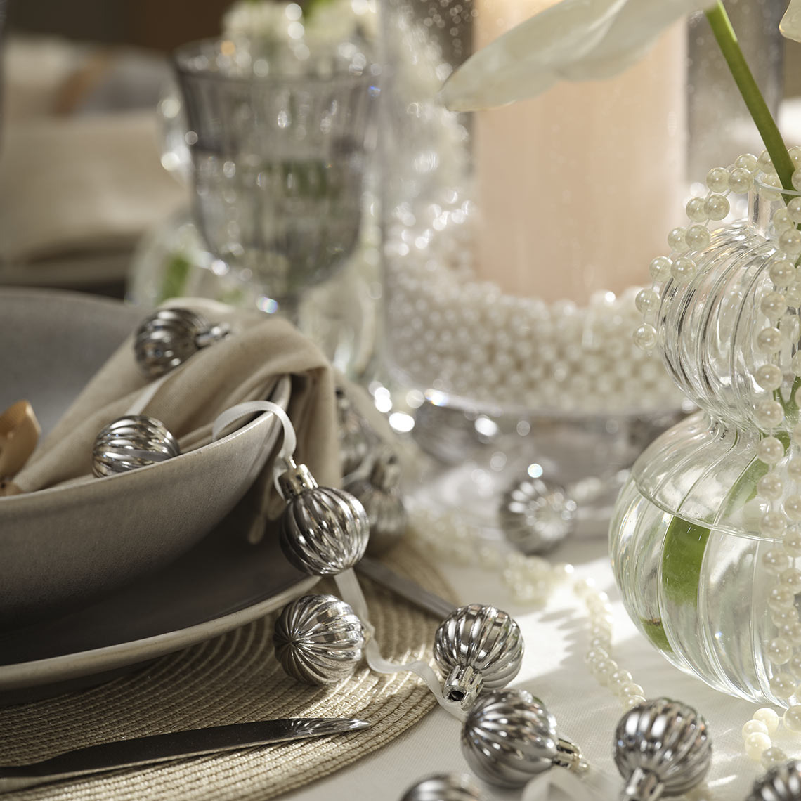 Christmas baubles on a string on a dinner table