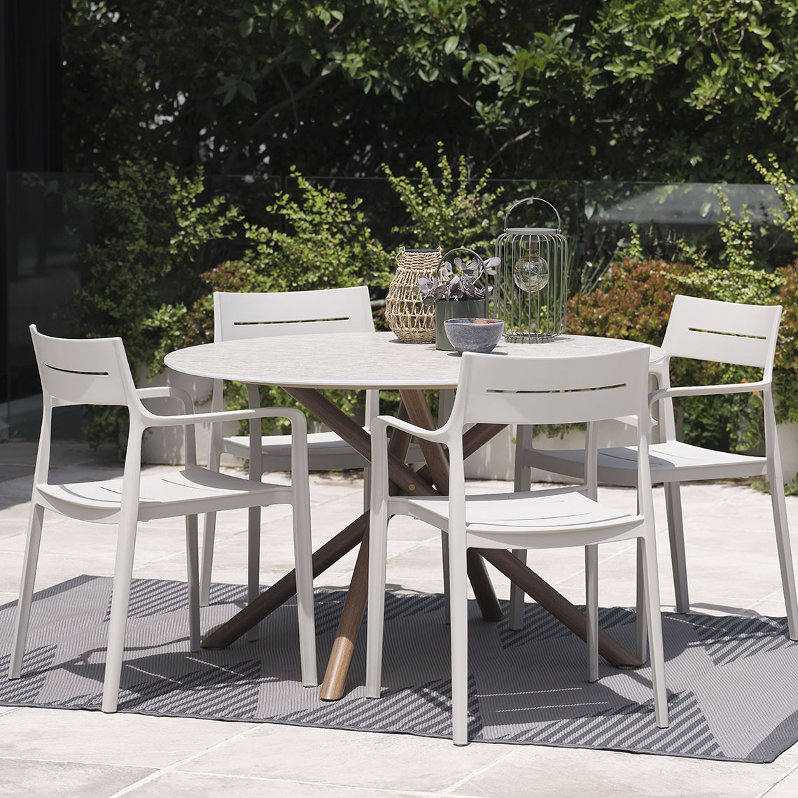 Round garden table and outdoor chairs on patio in garden
