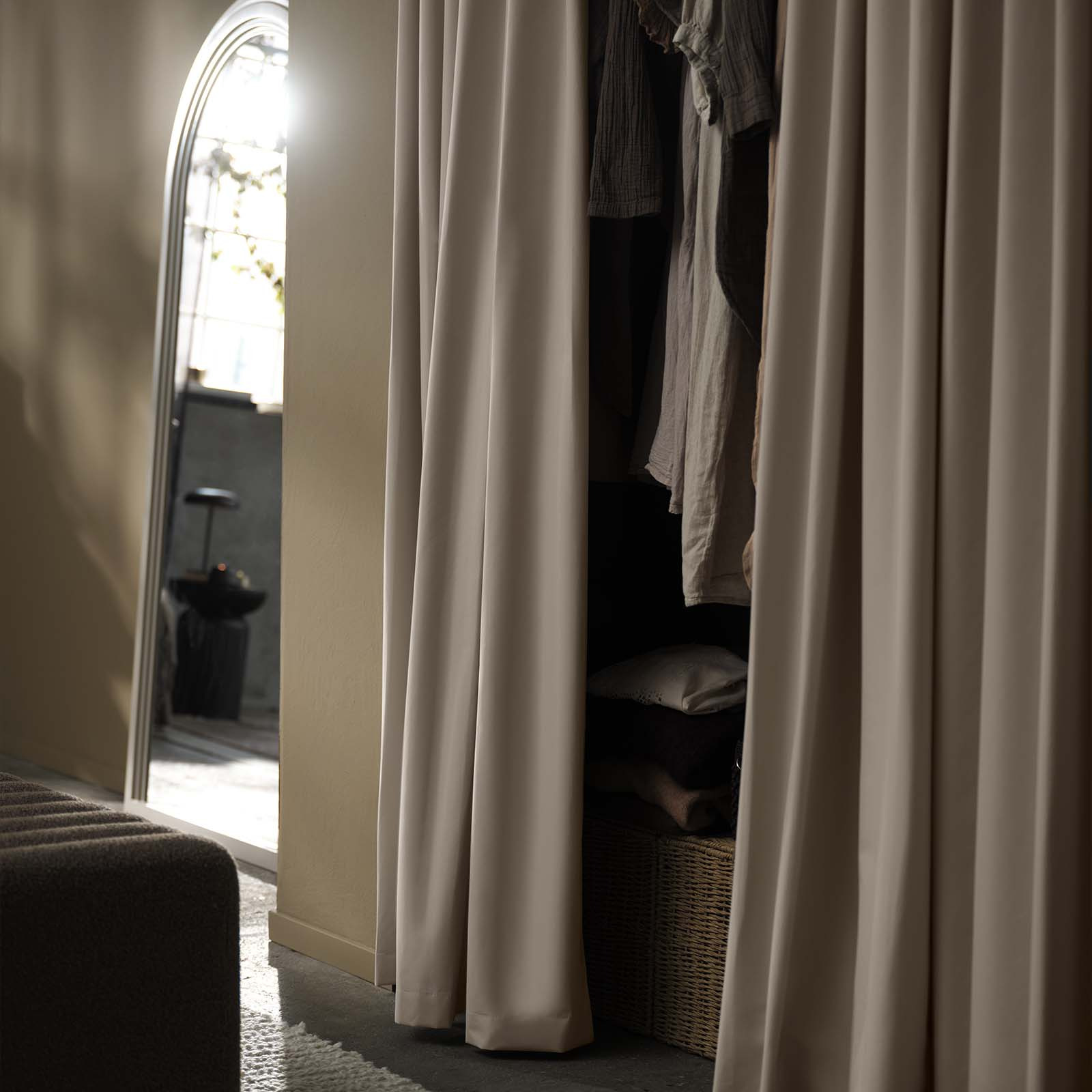 Beige blackout curtain used as decorative fronts for wardrobe in bedroom