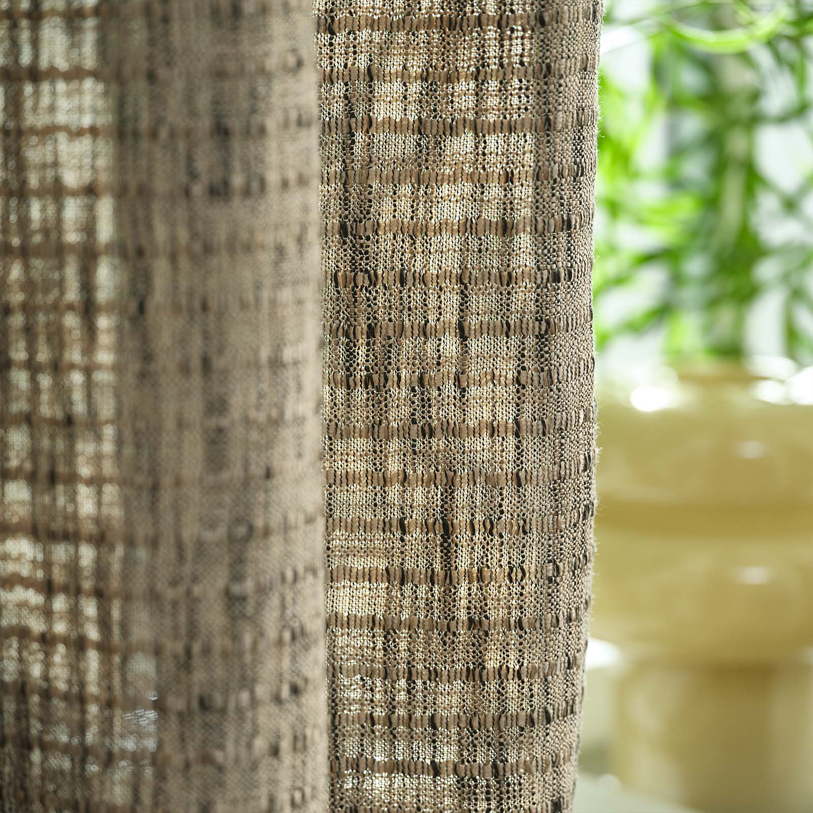 Close-up of a sandy, green-coloured heavy curtain in front of window
