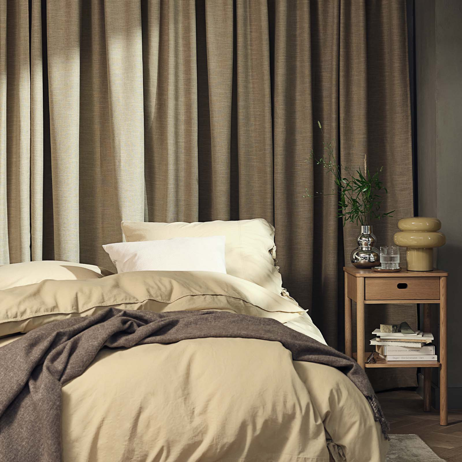 Bedroom with large heavy curtain in khaki colour 