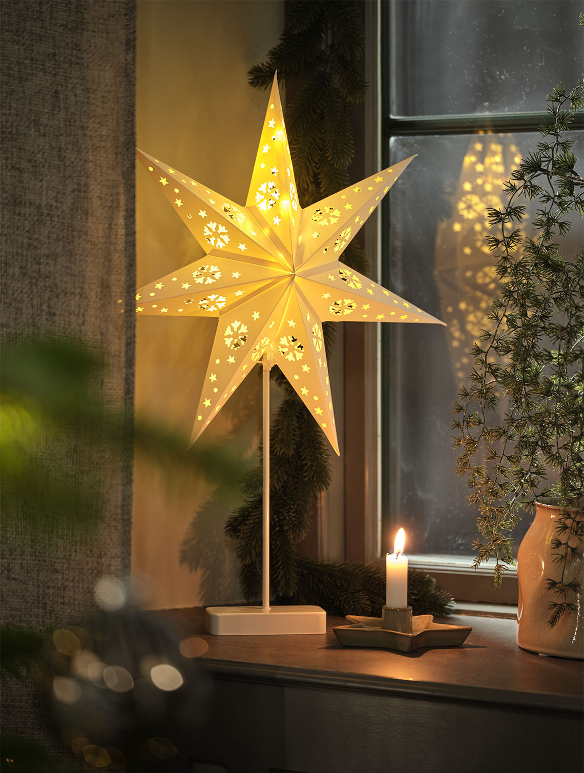 Star-shaped light illuminating a window inside a home