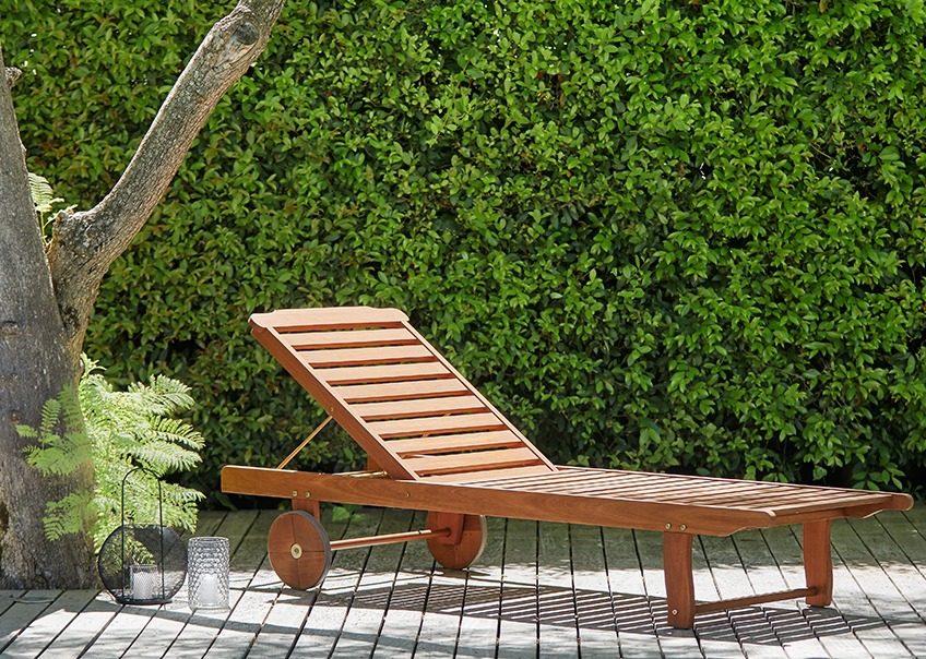 Wooden sun lounger on a sunny patio 