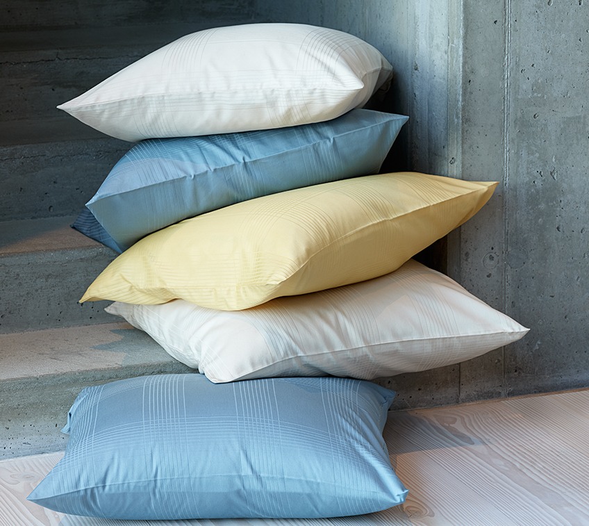 Pile of pillows with covers on petrol, sand and yellow