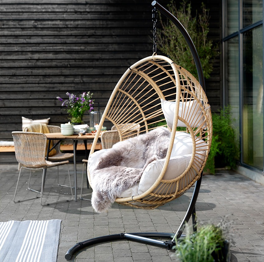 Patio with a hanging chair and dining set in the background