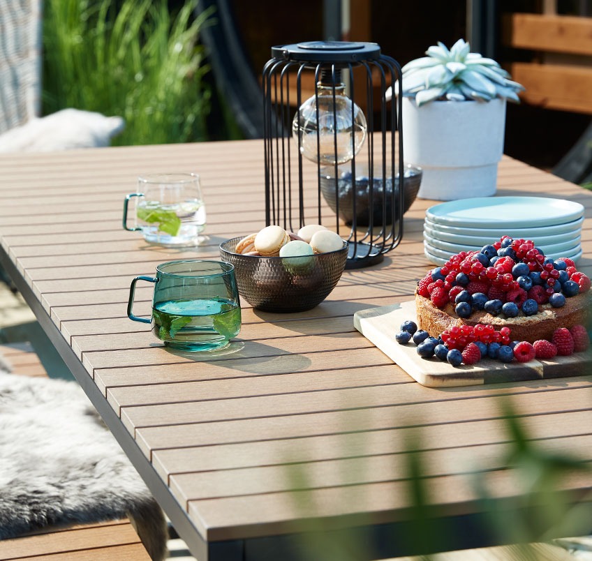 DAGSVAD garden with RUGDE solar lamp and ANDERS mugs Garden table with cookies, cake and mugs