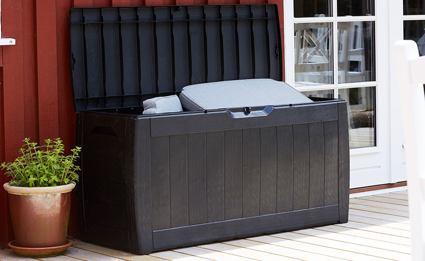 Black cushion box with an open lid on a patio
