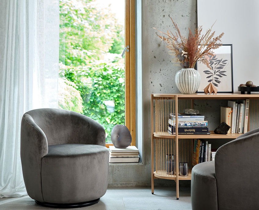 Grey armchair and sideboard with books and vase 