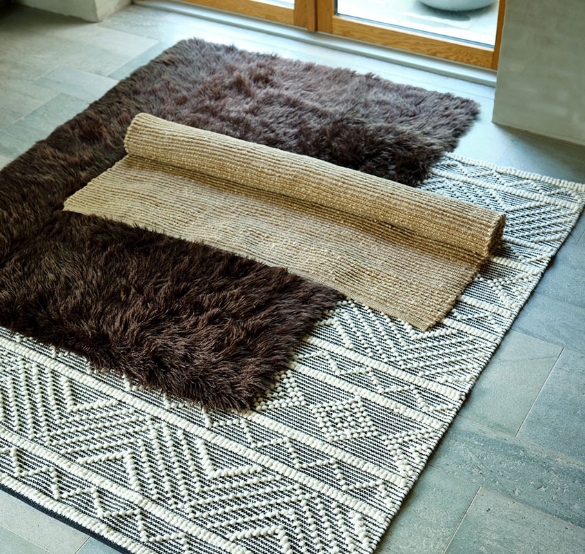 Brown STORMHATT rug, patterned VANDMYNTE rug and jute GLORIOSA rug Brown rug, patterned rug and jute rug on the floor